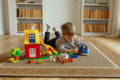 Little boy playing with toys in the bedroom. 