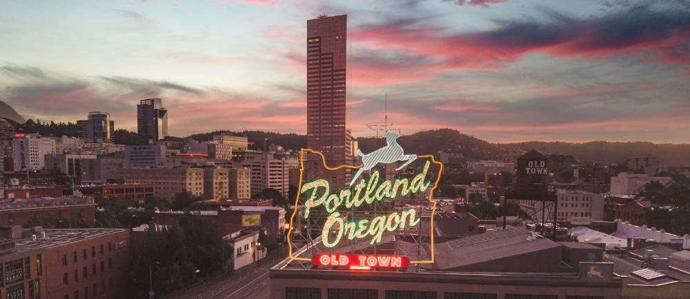 A Portland Skyline with a neon sign infront