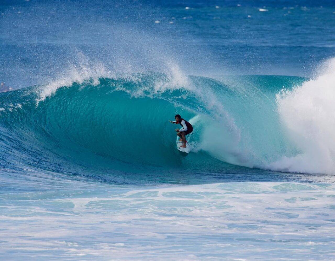 Kei rides a wave in the ocean