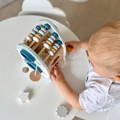 Top view on the beads counting game of the Montessori Learning Rocket and a little boy playing with it.