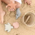 Toddler playing with Montessori Silicone Beach Set in the sand.