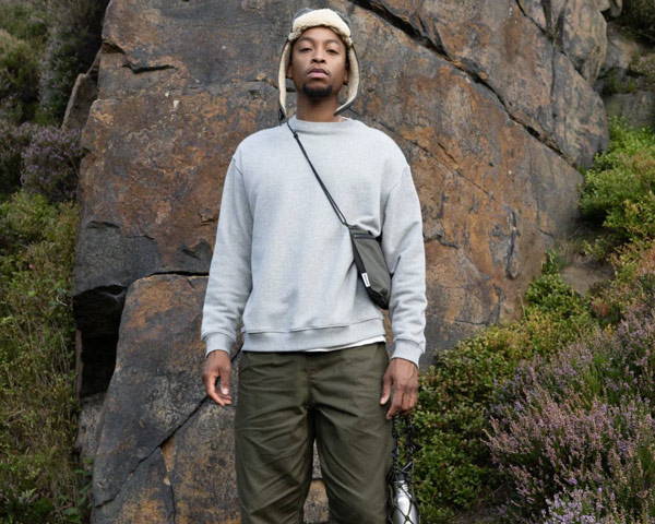 Man wearing organic cotton sweatshirt in grey marl with khaki organic cotton trousers from sustainable menswear brand wawwa based in Manchester in the UK