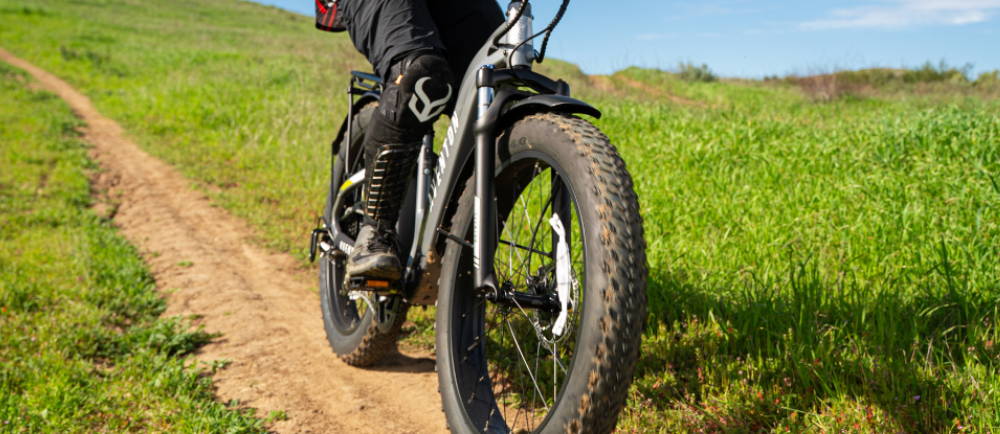 a person riding a green Aventon Aventure fat tire electric bike