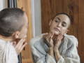 woman looking in the mirror at her face