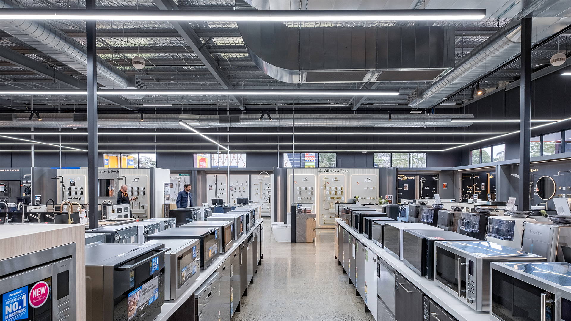 Minimalist commercial lighting design using pendant and track lighting to guide movement, improve visibility and match the brand’s contemporary interior.