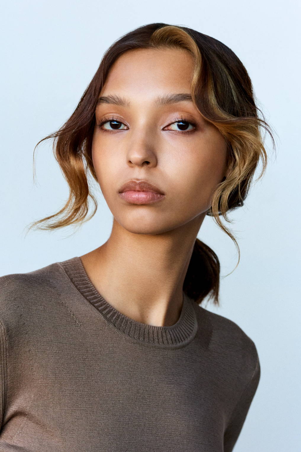 Davines hair model with a textured, messy ponytail