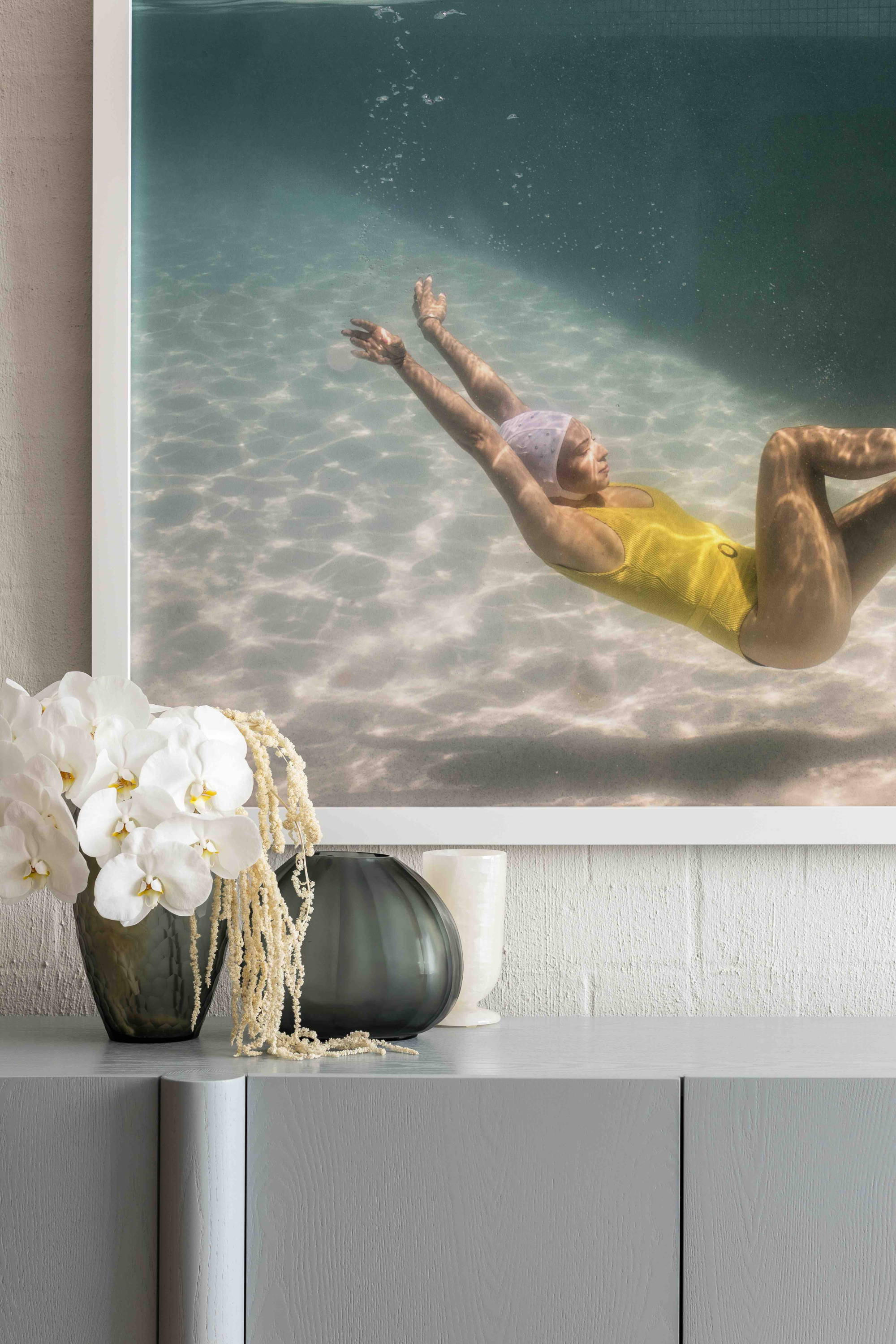 Halcyon Daze 1 by Francesca Owen - Underwater photography of a synchronised swimmer in yellow leotard and white cap posing underwater.