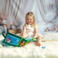 Girl smiling while going through her Montessori Santa's Book filled with interactive Christmas-themed pages.