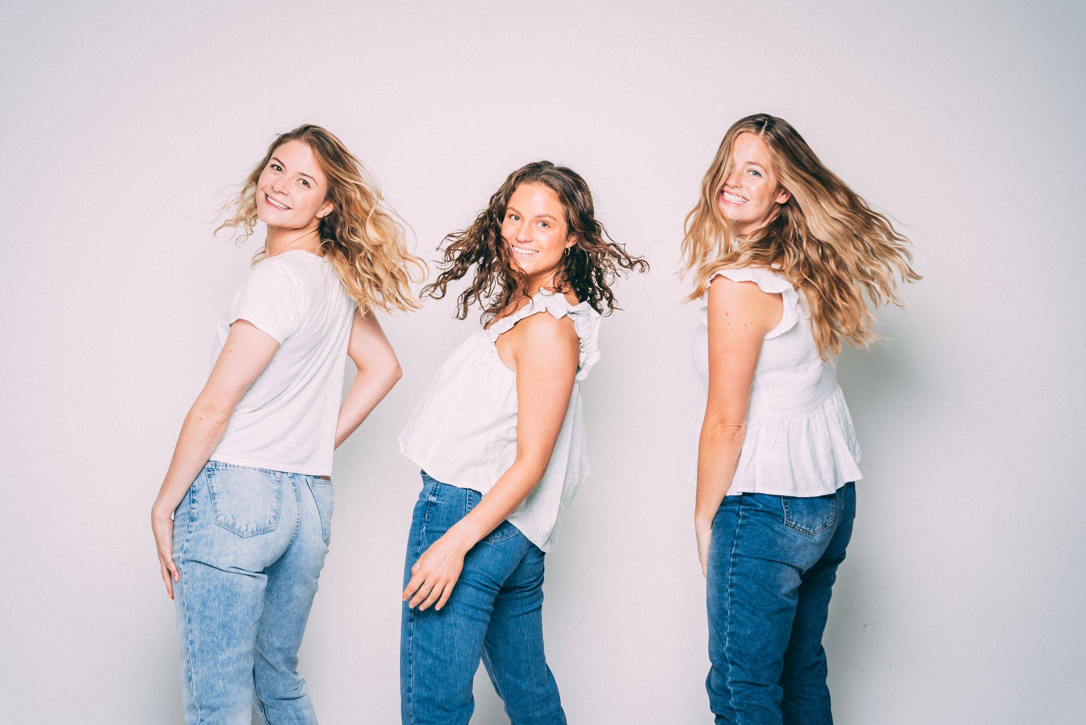 Image of three women with a wavy hair showing happiness