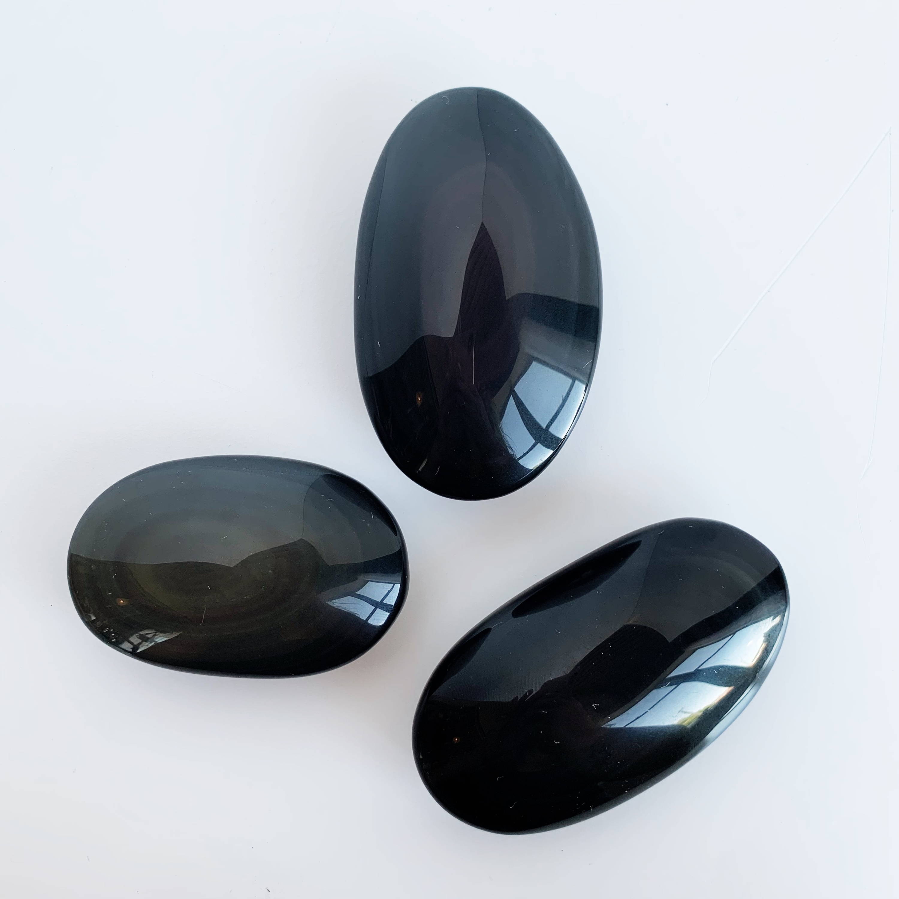Rainbow Obsidian Palm Stones on a white background