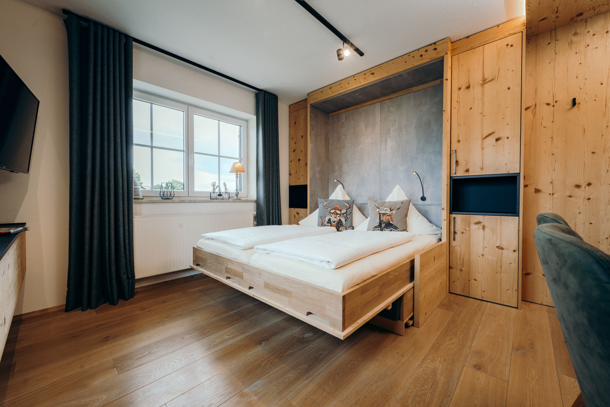 Das Sofa im Wohnzimmer umgewandelt in ein weiß bezogenes Doppelbett mit Hirschkissen.