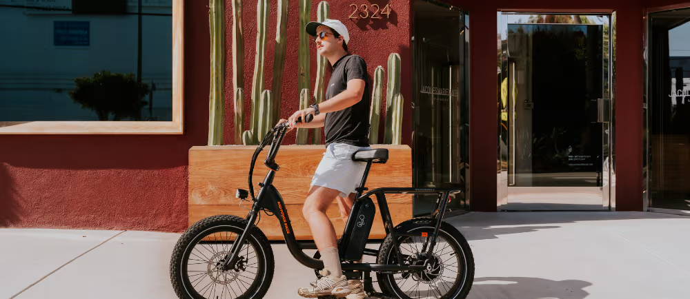 An E-Biker On A Small Bike Outside An Appartment Block