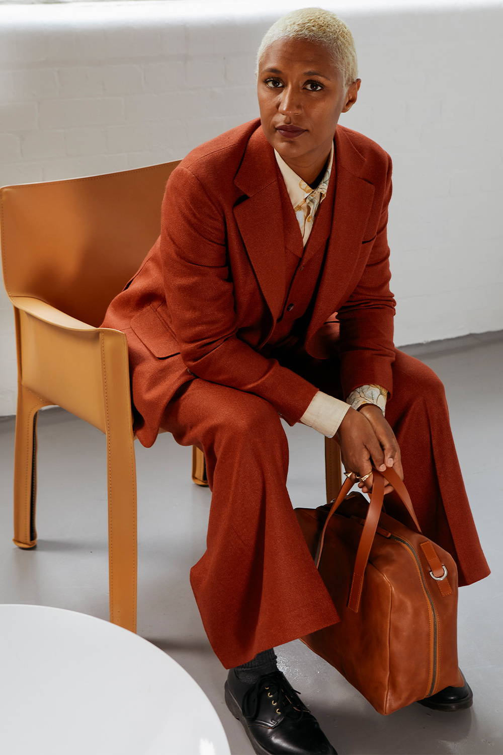 Maya Njie Siting on Aram chair holding Jago bowler bag