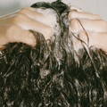 hands scrunching wet hair with shampoo suds