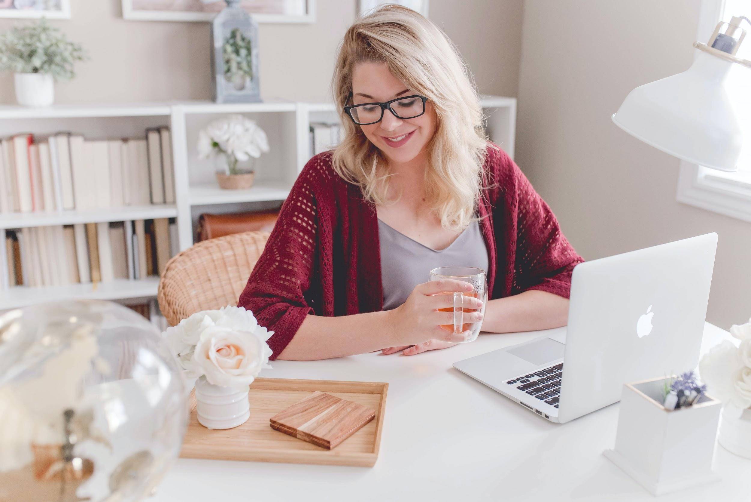 Professional women with glasses in front of a laptop in a stylish work from home office