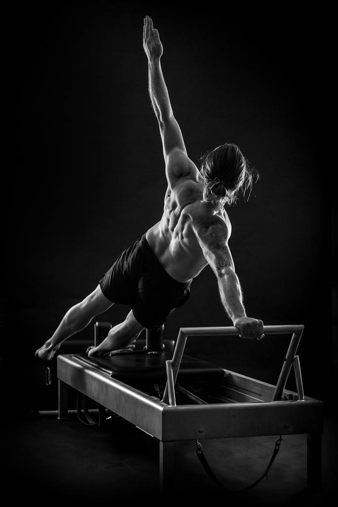Black-and-white photo of Miguel Silva on the Pilates Reformer