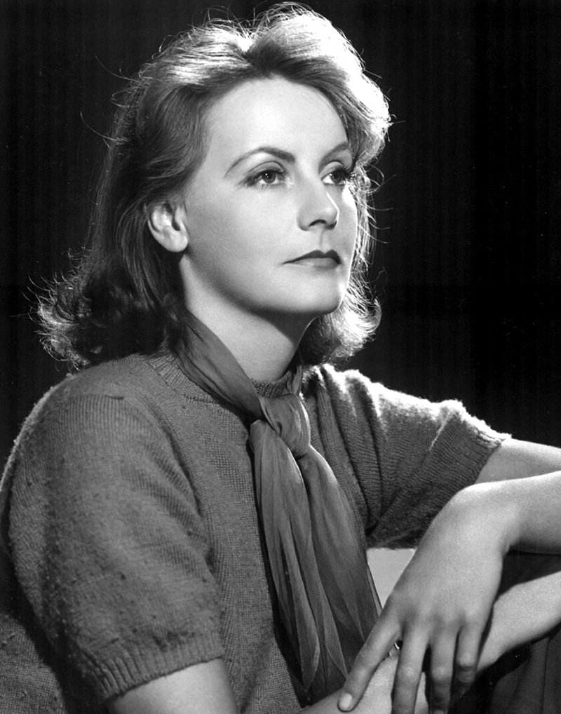 A promotional image for the film, featuring a Greta with a stern look on her face, looking forward with her arms folded on knees.