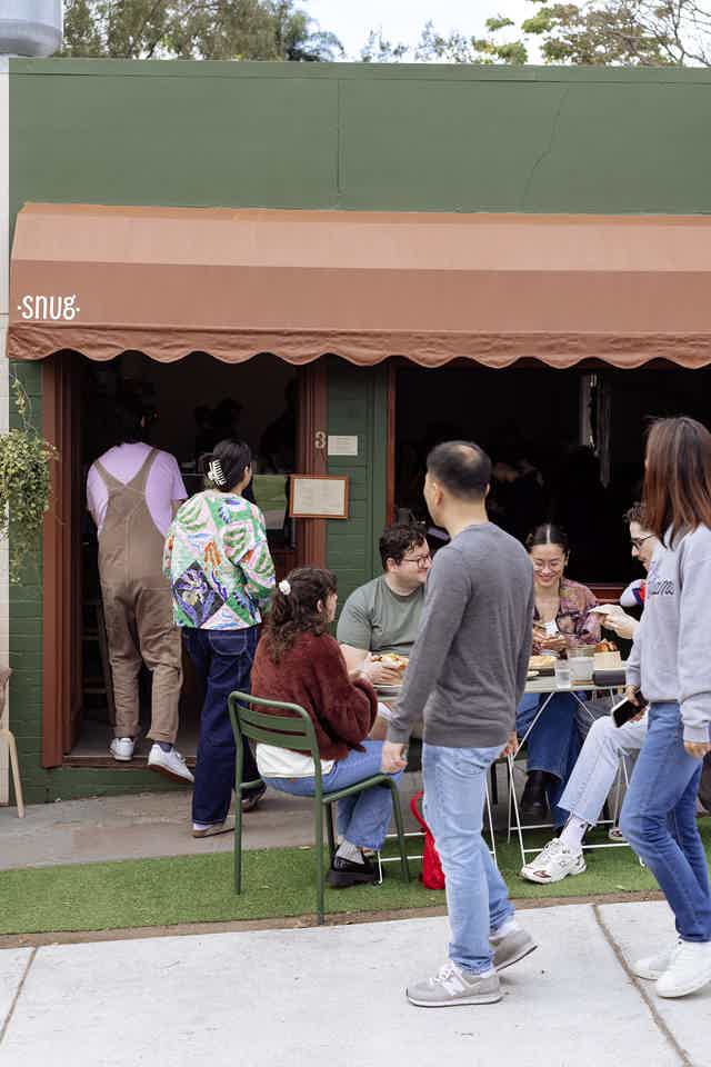 Barista serving two people their coffees 