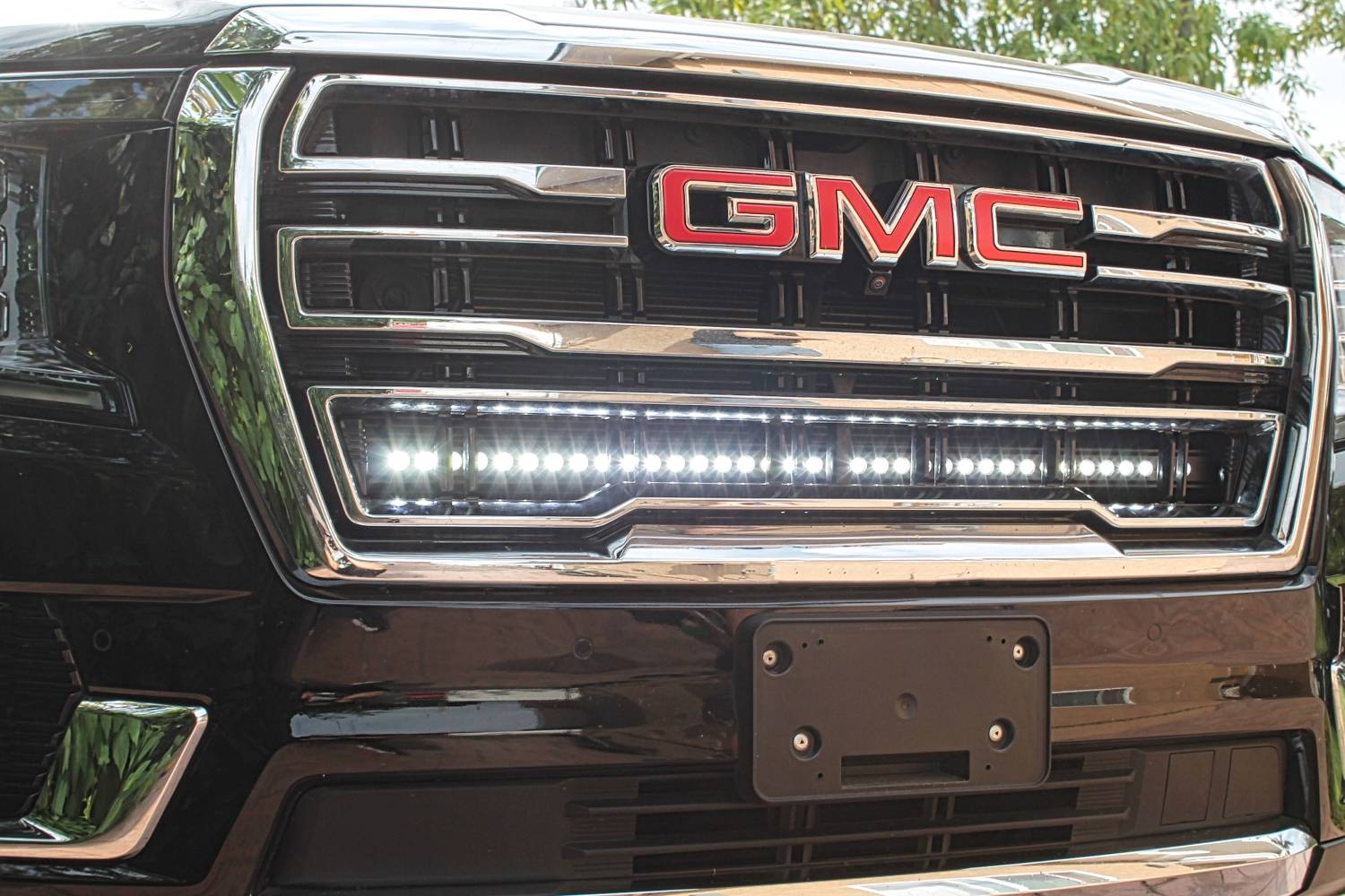 gmc yukon with one 40in white light bar behind the grille by mandr automotive