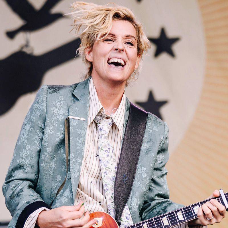 Image may contain: Brandi Carlile, Face, Happy, Head, Person, Laughing, Accessories, Formal Wear, Tie, and Guitar