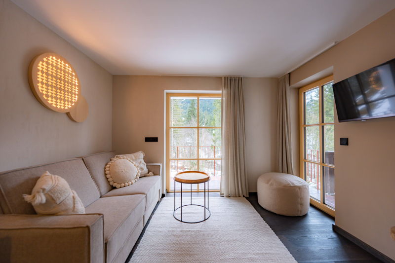 Heller Wohnbereich mit Sofa und Fenster im Apartment Waldgeflüster von Hugo & Pepi in Mittelberg im Kleinwalsertal.
