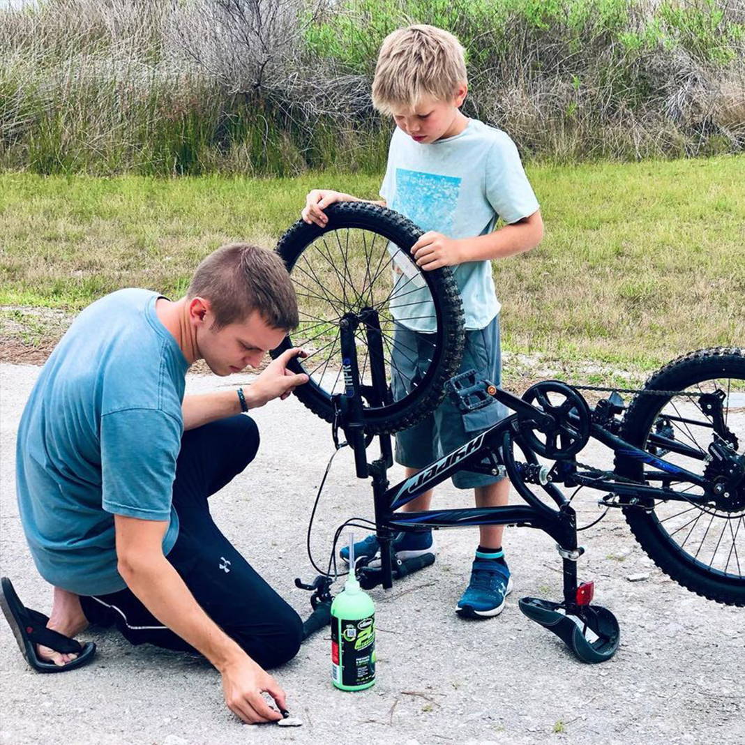 Father Installing Slime 2-in-1 Tire & Tube Sealant into Kids Bike