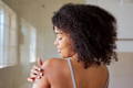model looking at her skin on the back