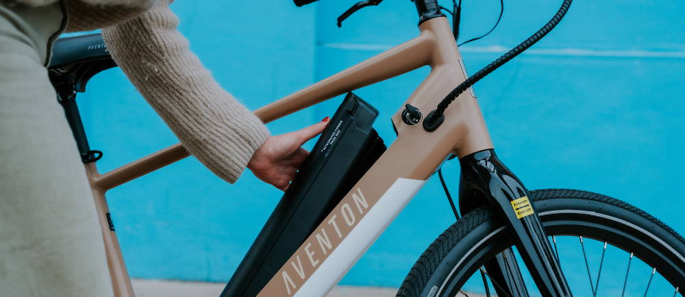 Rider removing battery of Aventon Pace electric bike