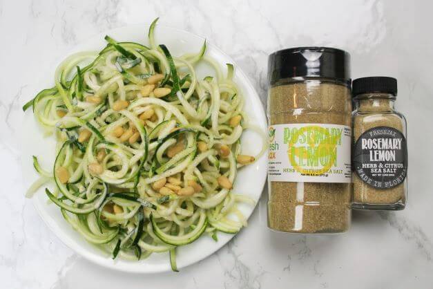 zucchini noodles with creamy rosemary lemon sauce next to a large bottle of FreshJax Organic Rosemary Lemon Sea Salt.