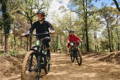 Deux hommes sur vélos électriques VTT sur un chemin en forêt