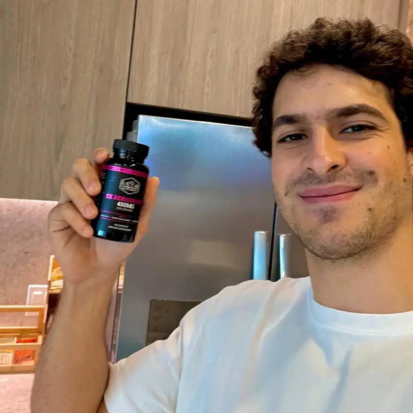 A smiling woman holding a berberine bottle