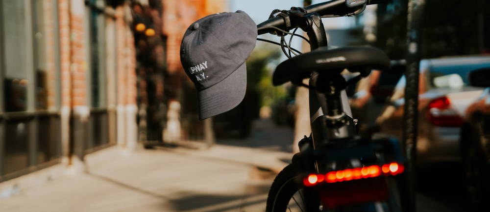 an upway ball cap on an electric bike in a city