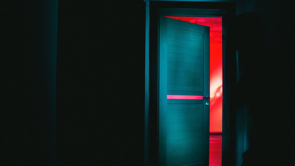 offener Türspalt mit roten Licht dahinter
