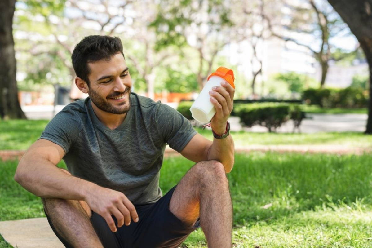 athlete relaxing and drinking protein