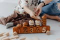 Mother and toddler playing with wooden Montessori stacking rings. 