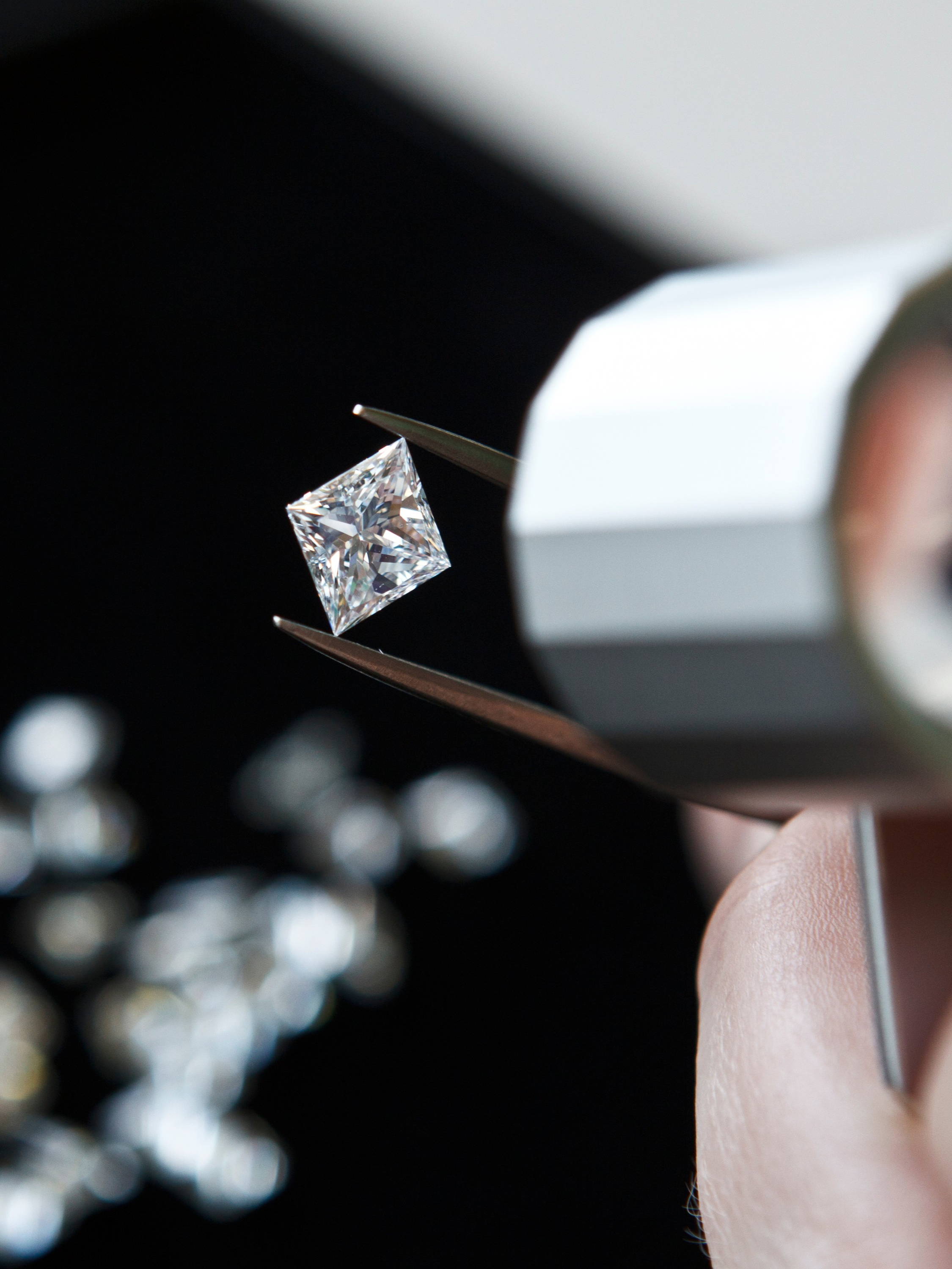 Diamond being held in tweezers and inspected