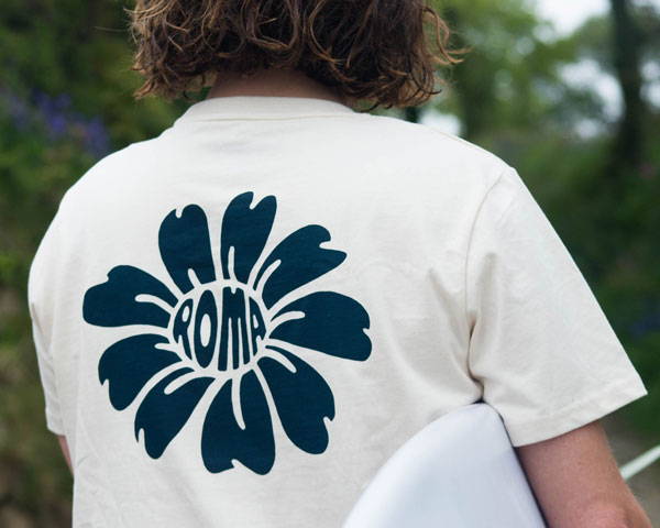 Man wearing ecru organic cotton t-shirt with print design by Hands For Feet, created by Cornish surf clothing brand Roma Surfshop