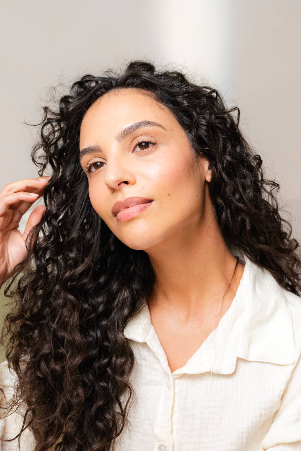 Davines hair model with long, dark curls