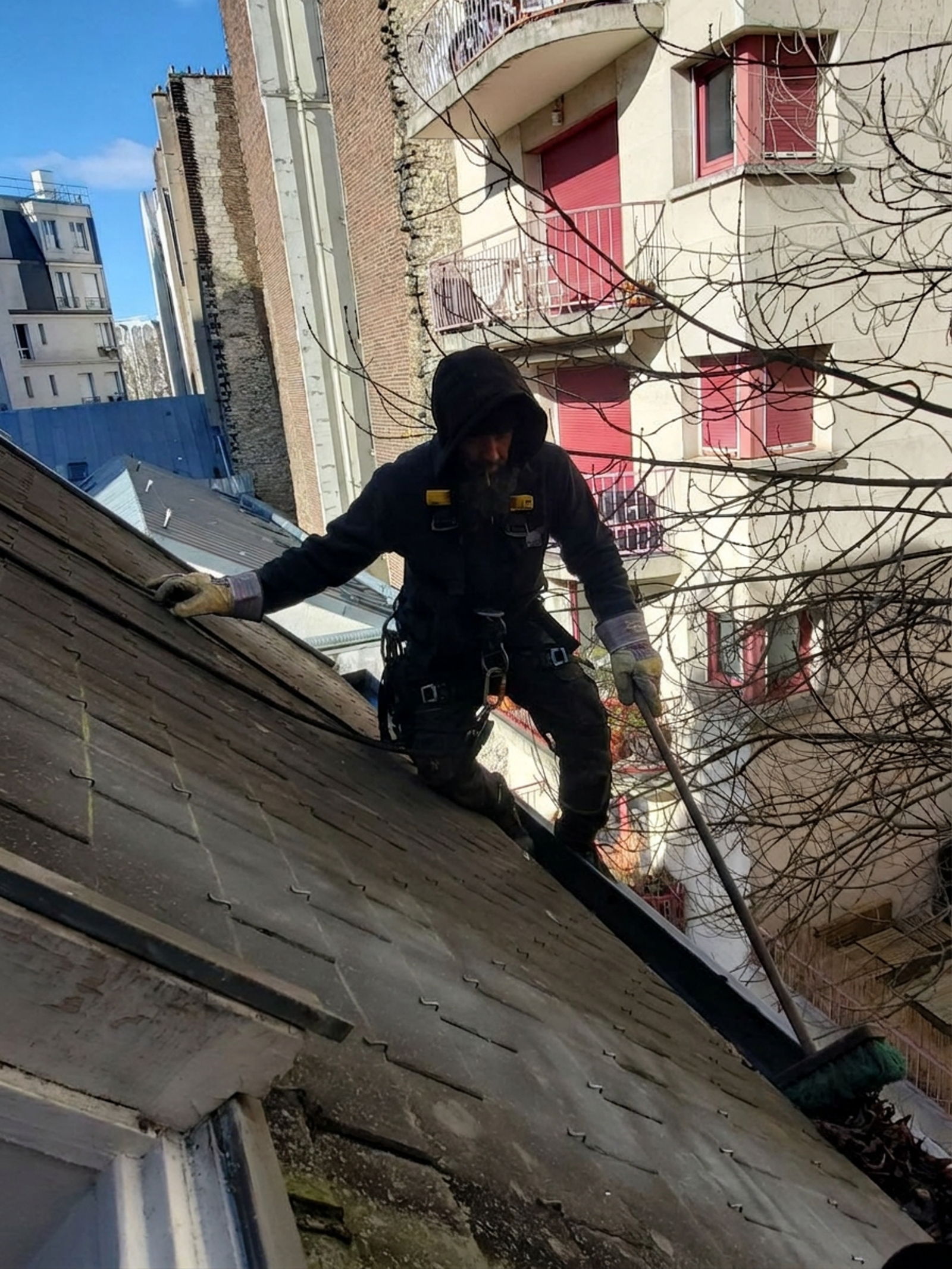Couvreur-cordiste à l'œuvre sur une toiture en pente à Paris