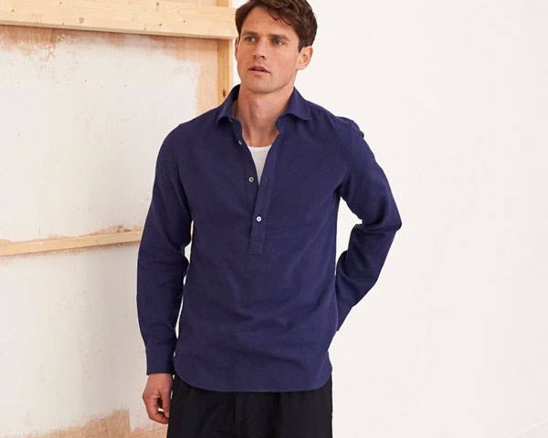 Man wearing navy blue organic cotton and recycled cotton popover shirt from sustainable men's clothing brand Neem, based in the UK