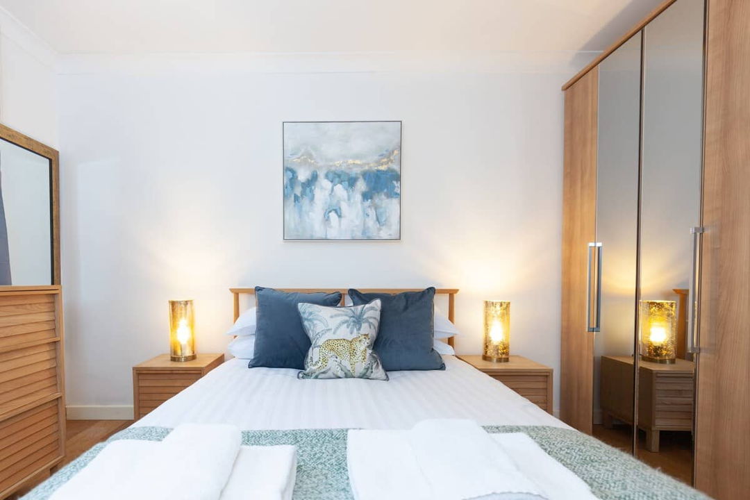 Bedroom showing large double bed with clothing storage and extra linen