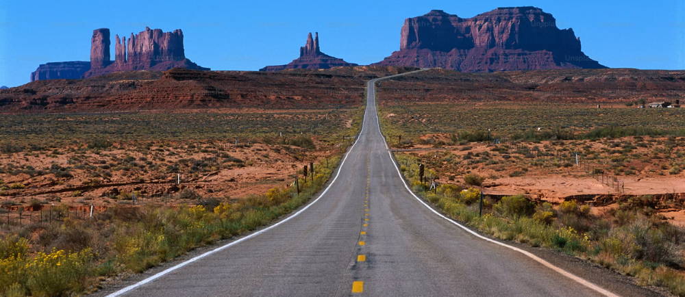 a road with rock formations in the background