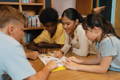 A group of children reading a book in a library.