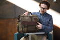 man sitting at a small table opening up his pilot briefcase