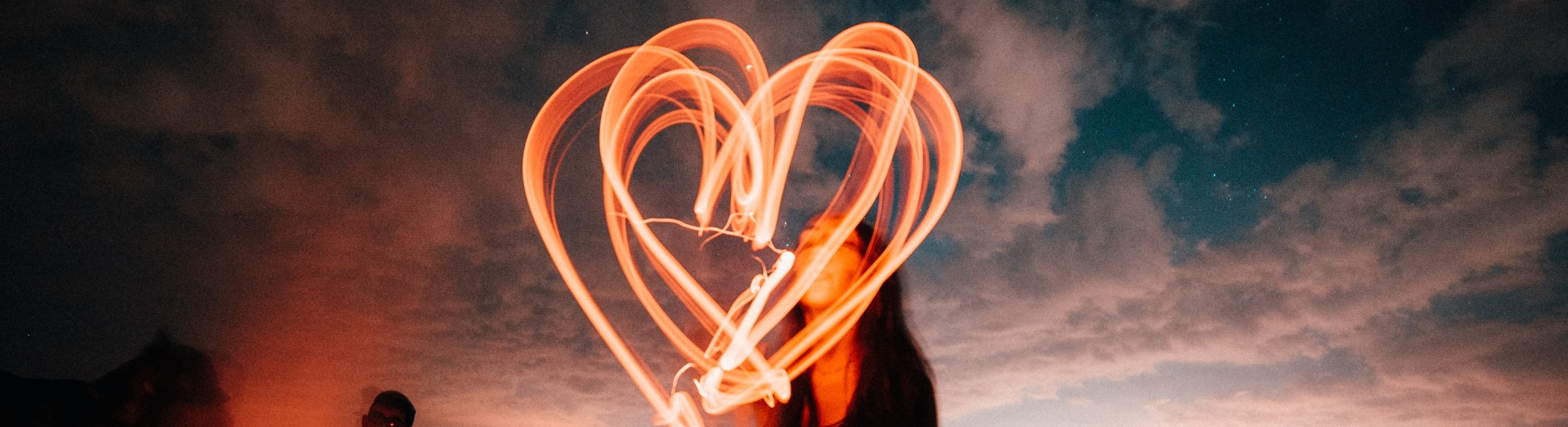 woman drawing a heart in light
