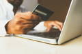Gros plan sur une personne en train de payer sur l'ordinateur avec une carte bancaire