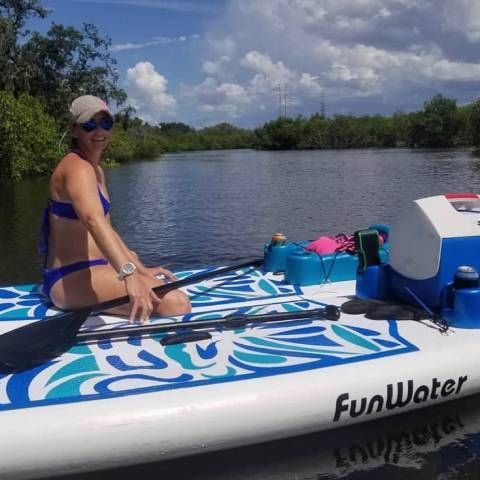 Customer sitting in blue TIKI stand up paddle board Toronto and smile
