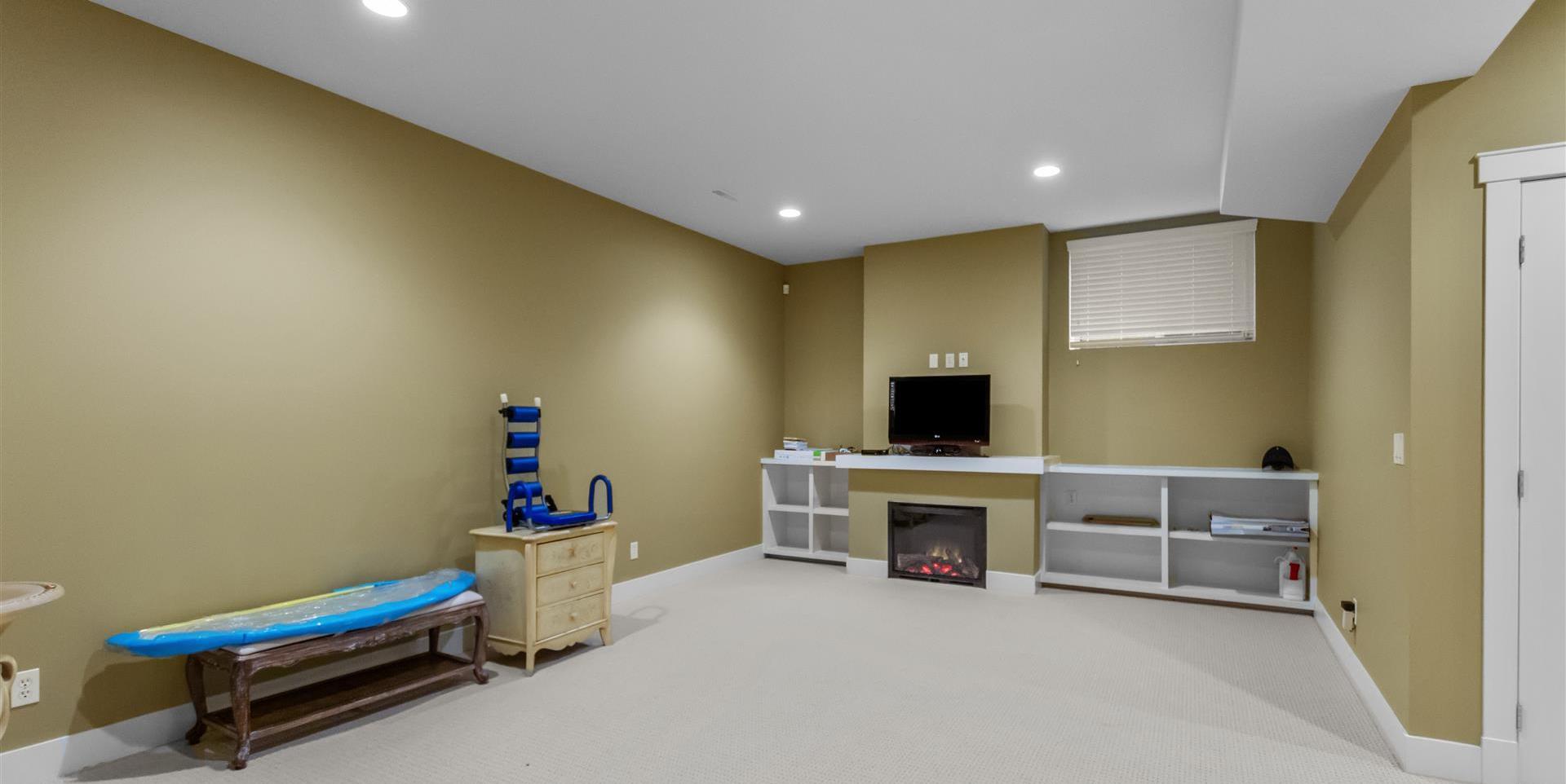 recreation room featuring a fireplace, carpet, and TV