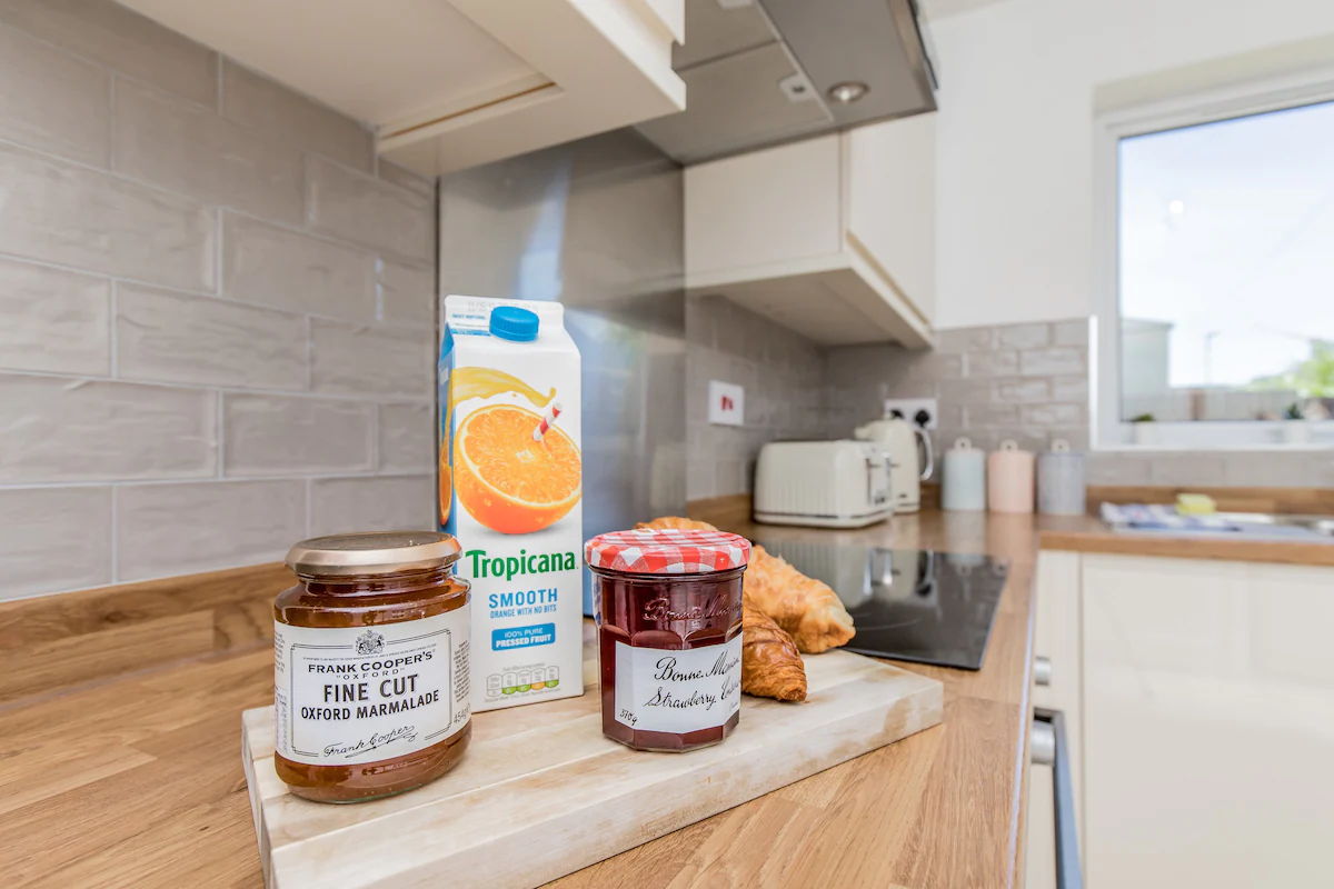 Close up shot in the kitchen of orange juice and fresh jam presented