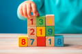 Baby holding Montessori wooden blocks with numbers. 